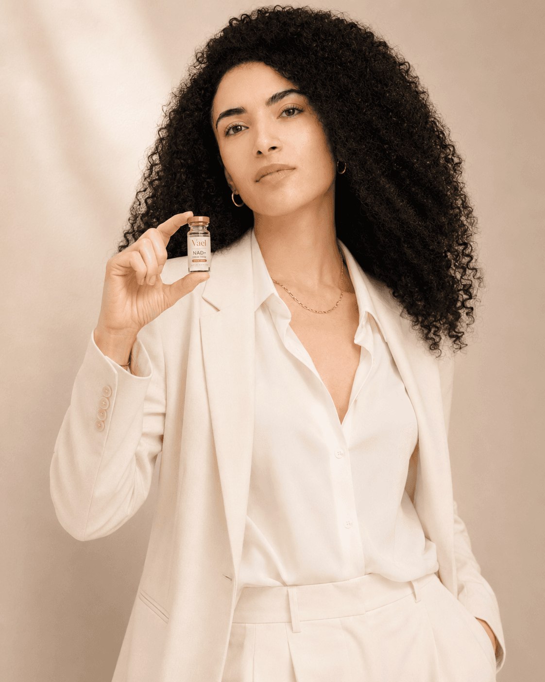 Woman holding Vael NAD+, warm and energized